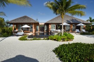 grosse private villa auf sand strand mit tollen pool im luxuriösen designer hotel und resort como parrot cay auf den turks- und caicoinseln in der karibik der garten ist gepflegt und eine palme steht davor